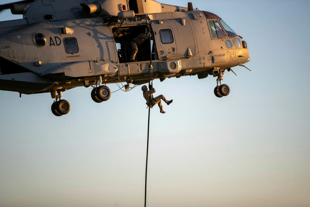 Soldier ziplining down a helicopter