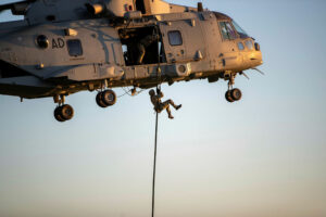Soldier ziplining down a helicopter