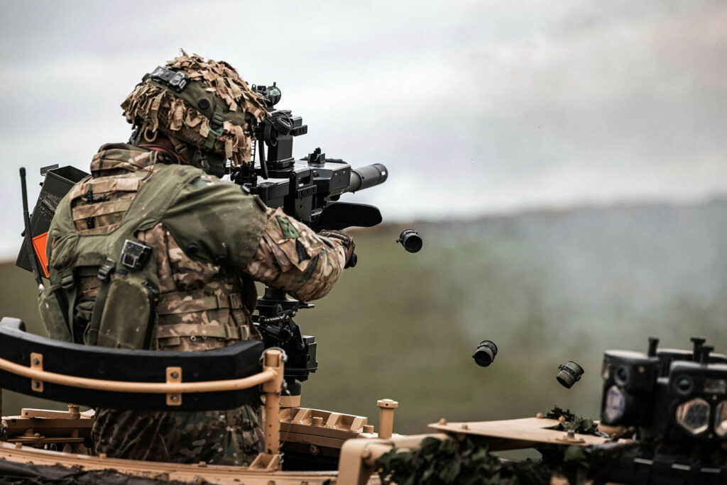 Over the shoulder shot of a soldier firing a machine gun