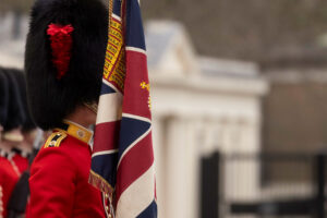 A soldier holding Union Jack partially covering their face