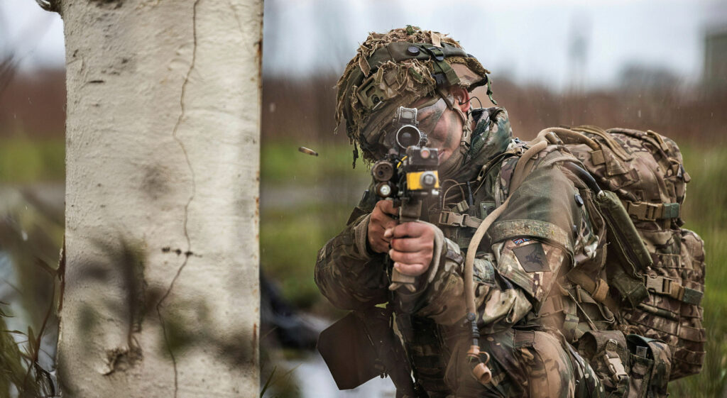 POV looking at a soldier firing a gun